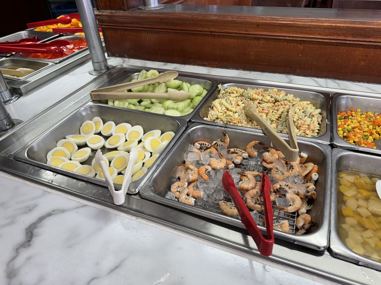 Steam-table trays of peel-and-eat shrimp, hard-boiled eggs, pasta salad and vegetables on a Chinese buffet line (not China Lee Buffet)