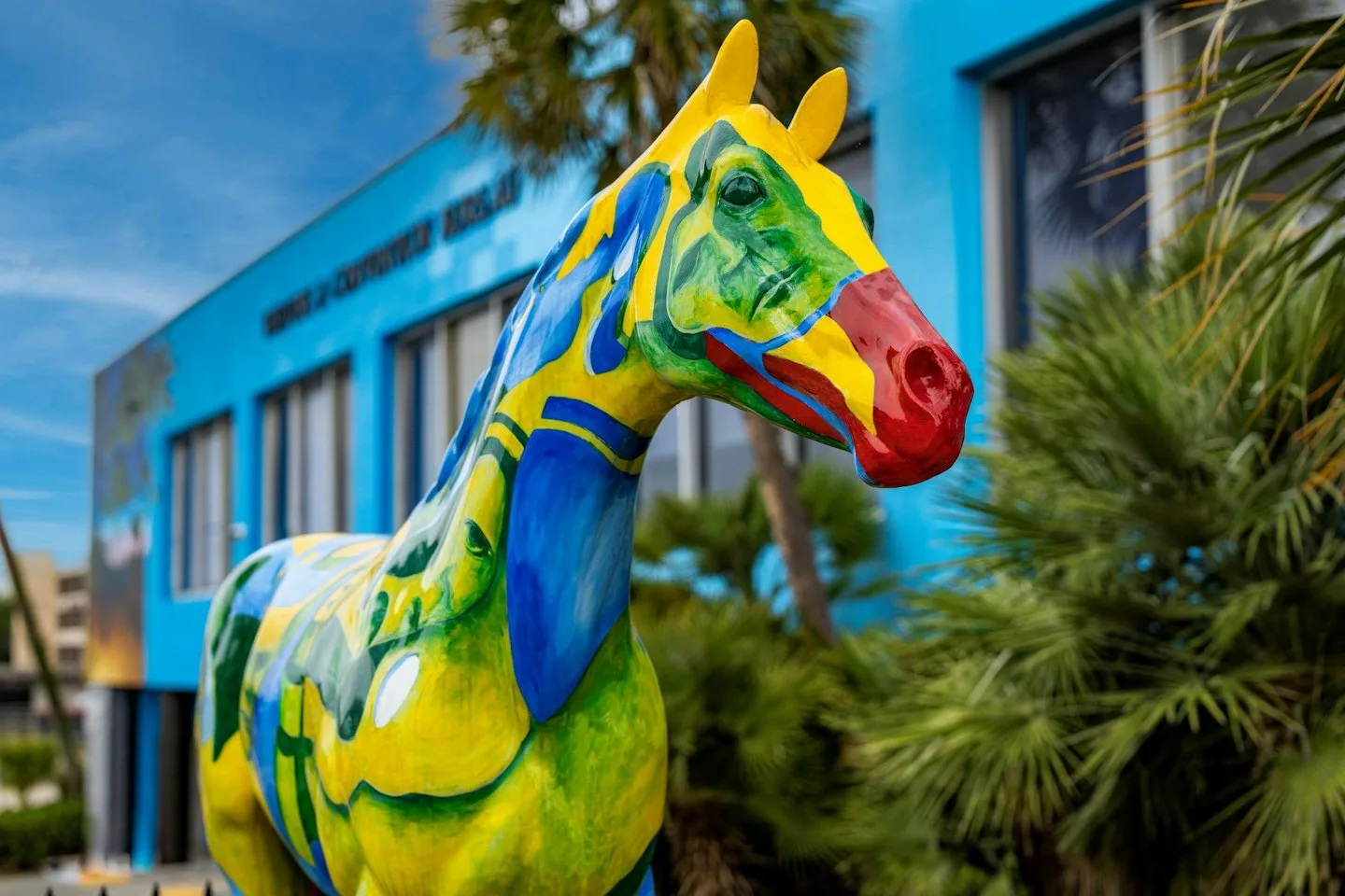 The Horse Fever statue "Travels" by Yani Mikedis, painted yellow, green, blue and red, outside the Ocala/Marion County Visitors and Convention Bureau