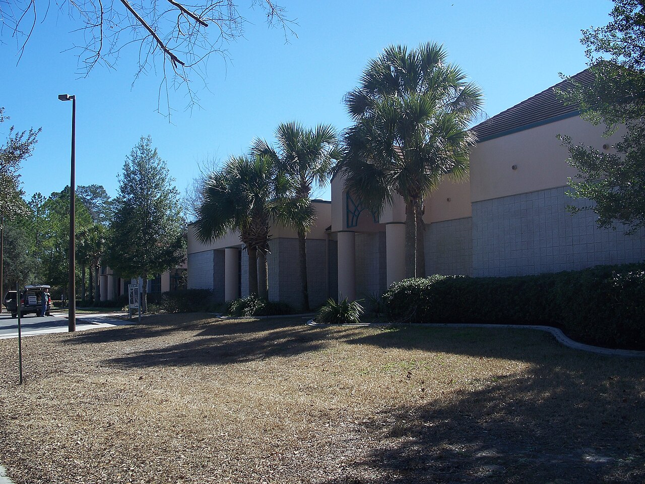 Tan stucco Marion Oaks Community Center building with columns and palm trees along the front