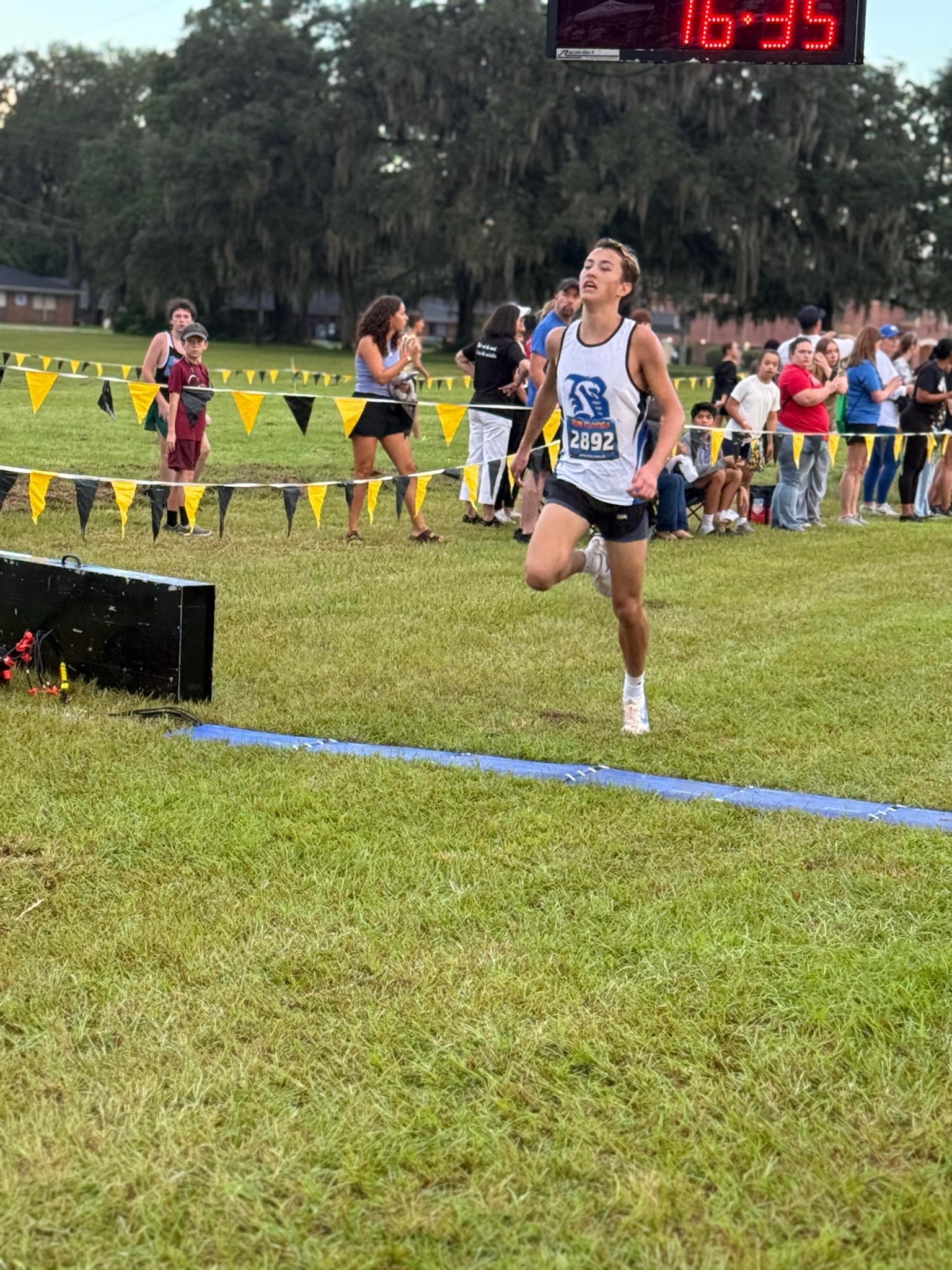 Belleview sophomore Asher Inman crossing the finish line as the clock reads 16:35 at the 2026 Buchholz Bobcats Classic